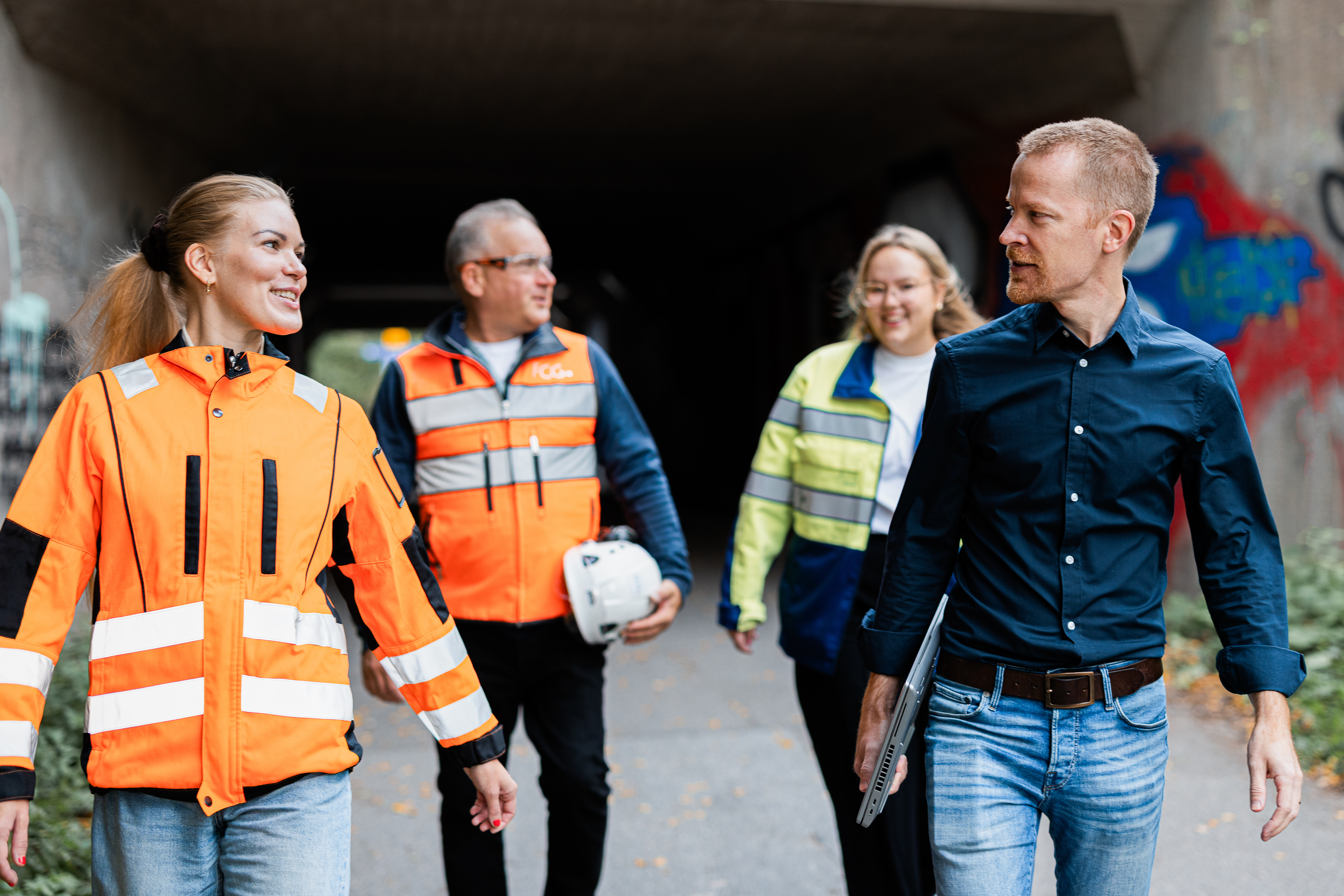 Four employees walking towards camera on a work site